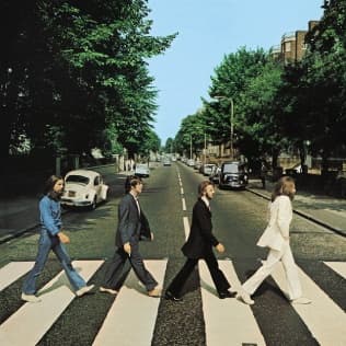 People walking across Abbey Road zebra crossing in London
