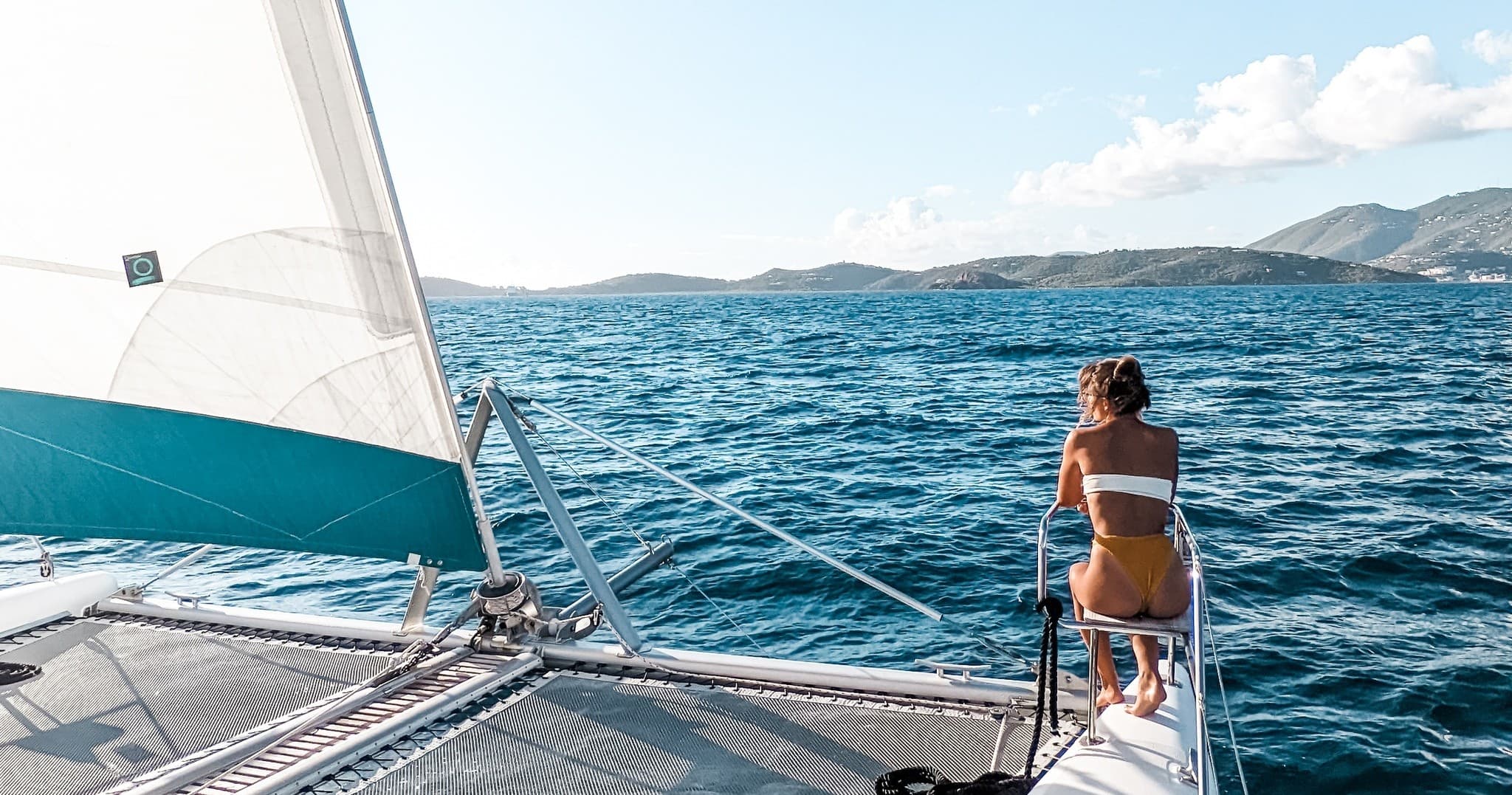 Passenger enjoying bow view on sailing catamaran in open sea