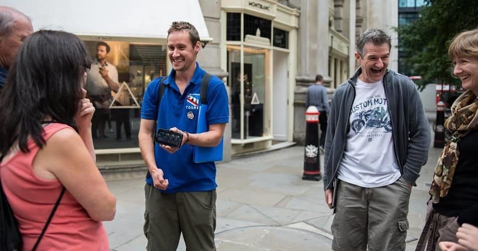 Tour guide leading small walking tour through London street