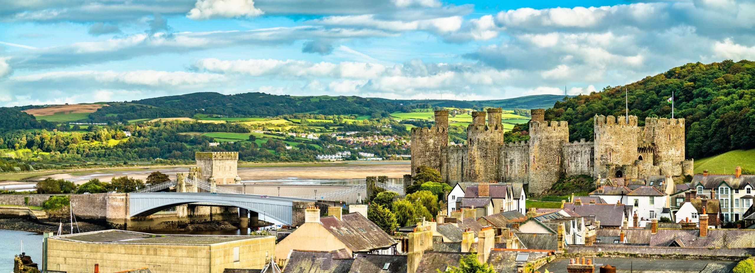 Sightseers exploring medieval coastal castle and river panorama
