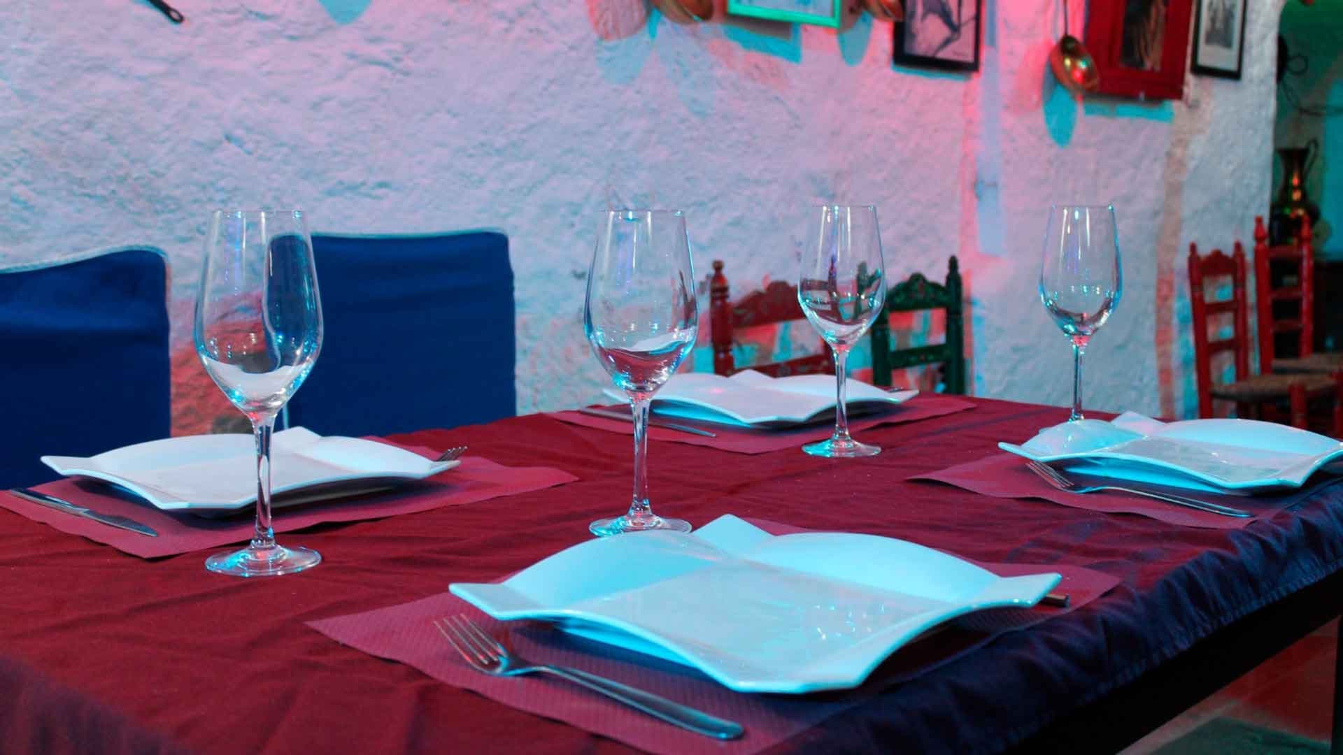 Intimate cave restaurant table set with wine glasses and menus