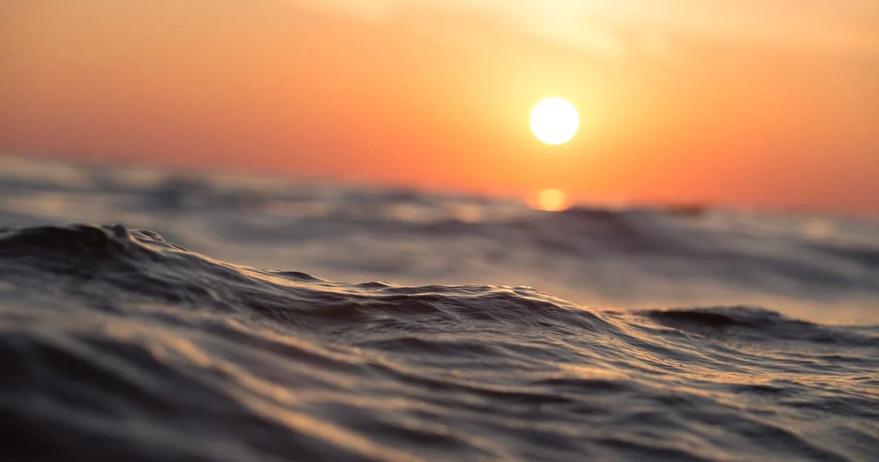 Sunset over ocean waves, coastal sea view for boating