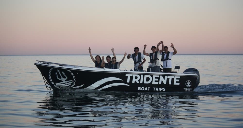 Sunset boat cruise with group celebrating on Tridente boat