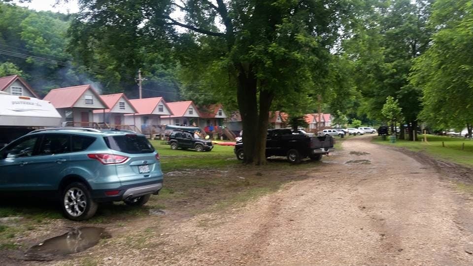 Gravel lane lined with park cabins and parked vehicles