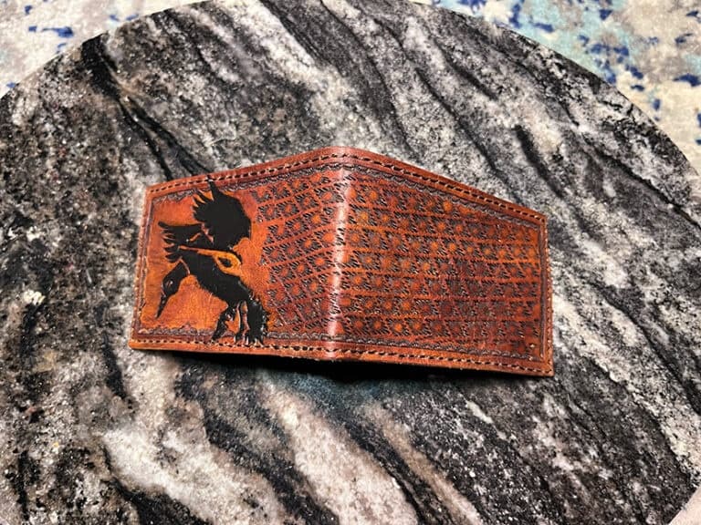 Hand-tooled leather wallet photographed on natural rock outdoors