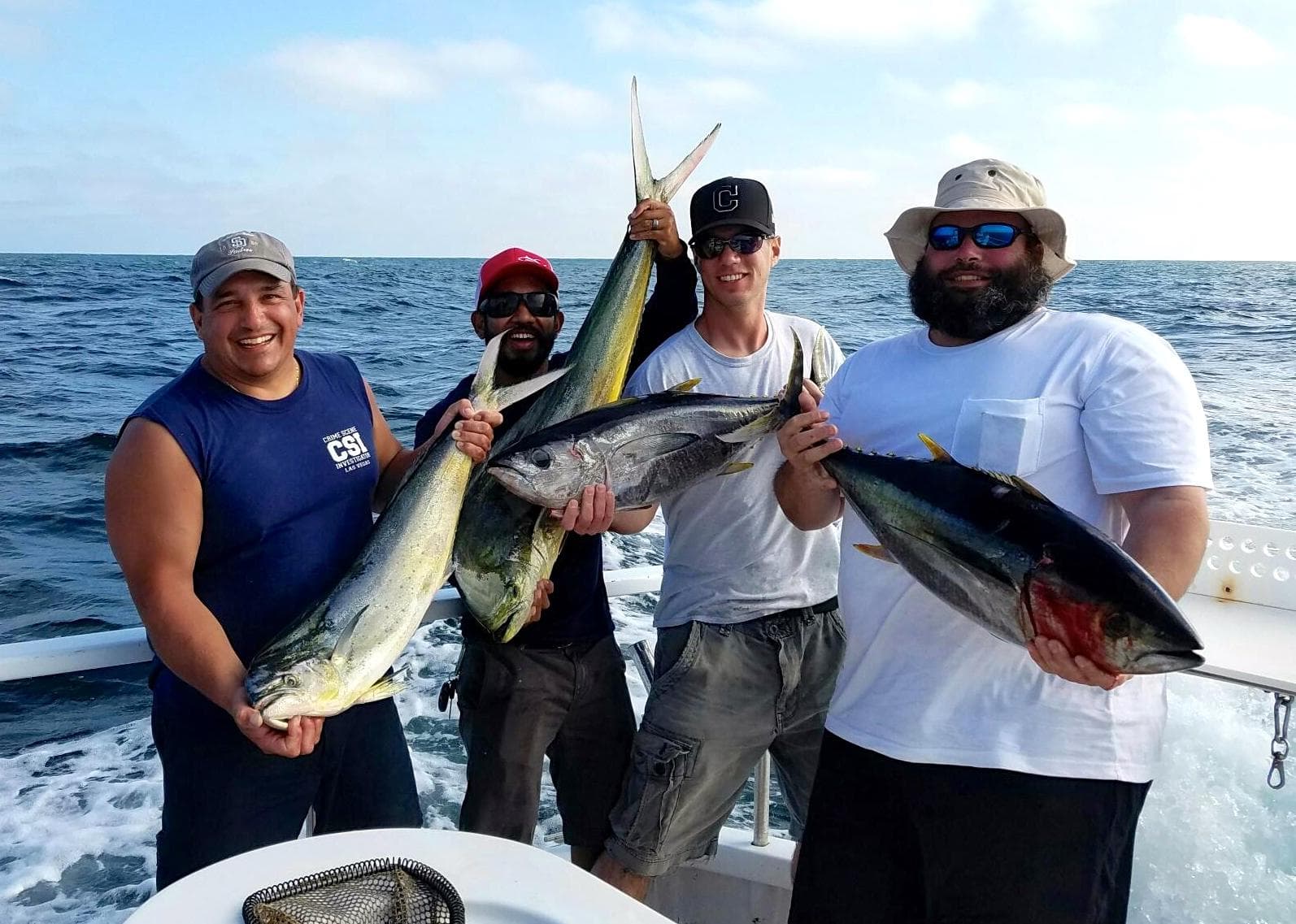 Crew displaying big offshore tuna against blue ocean horizon