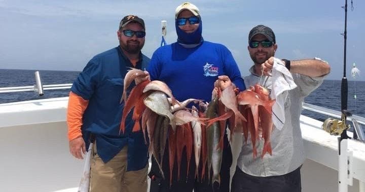 Charter anglers posing with red snapper catch on Gulf boat