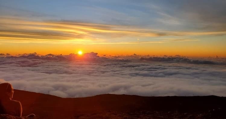 Golden sunrise over sea of clouds on Maui summit panorama