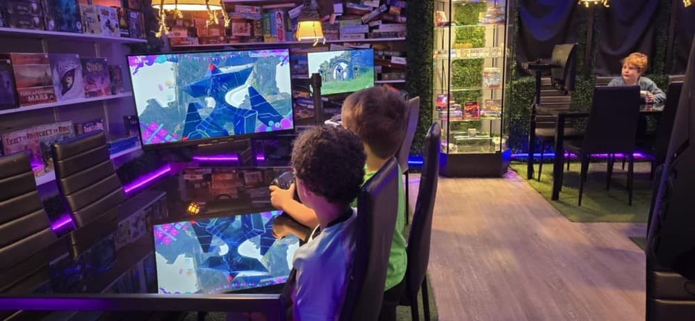 Children playing cooperative console game at glossy table in lounge
