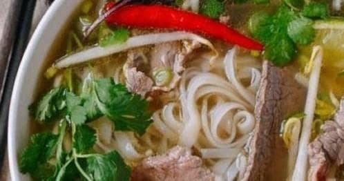 Bowl of spicy noodle soup with herbs for food tour tasting