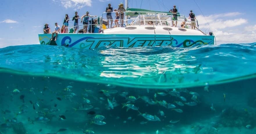 Glass-bottom tour boat with snorkelers over coral gardens