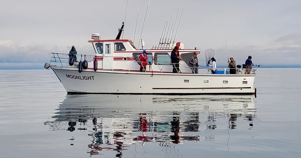 Fishing charter boat on calm Kodiak Alaska waters with anglers