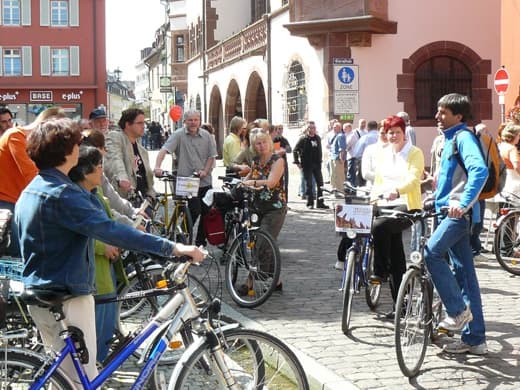 Group cyclists gathering in pedestrian street for city ride
