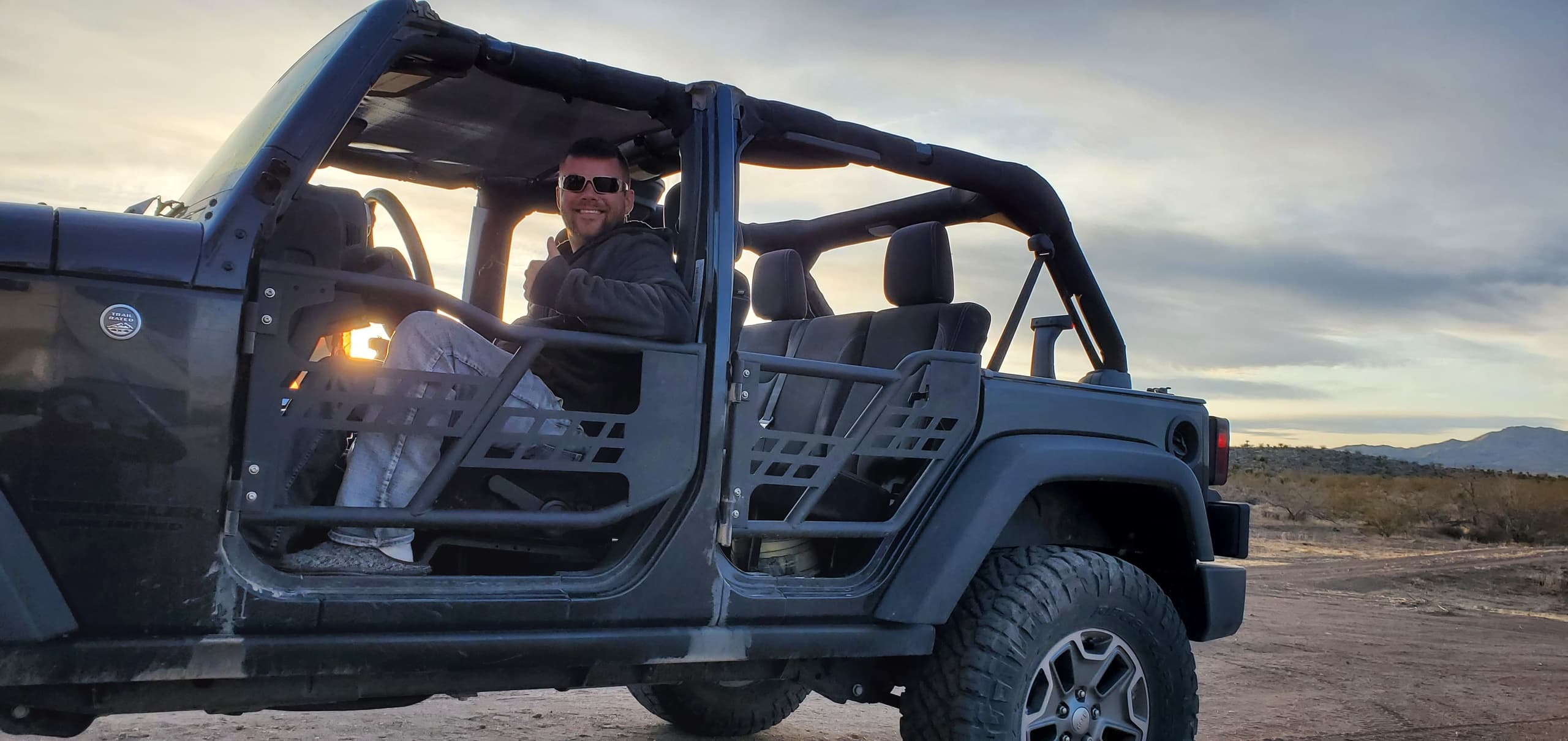 Jeep off-road tour with passengers enjoying sunset desert drive