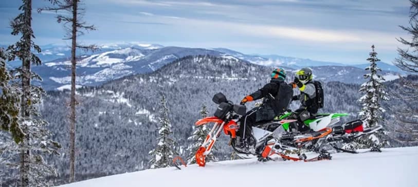 Snowmobile riders on snowy Tahoe backcountry ridge, scenic ride