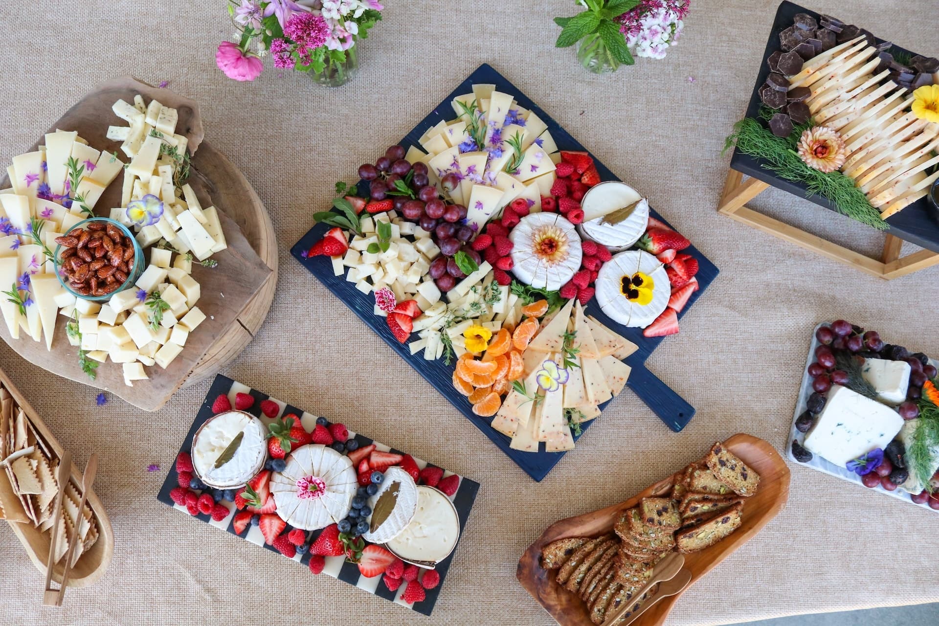Overhead cheese boards with fruit and crackers for picnic spread