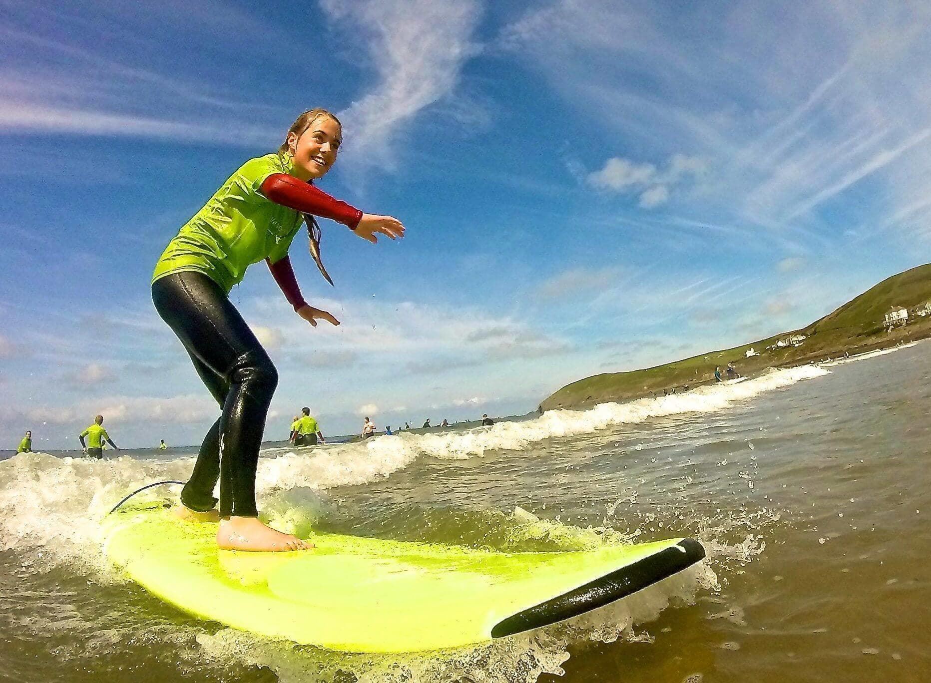 Surfer carving on yellow board in shallow coastal surf