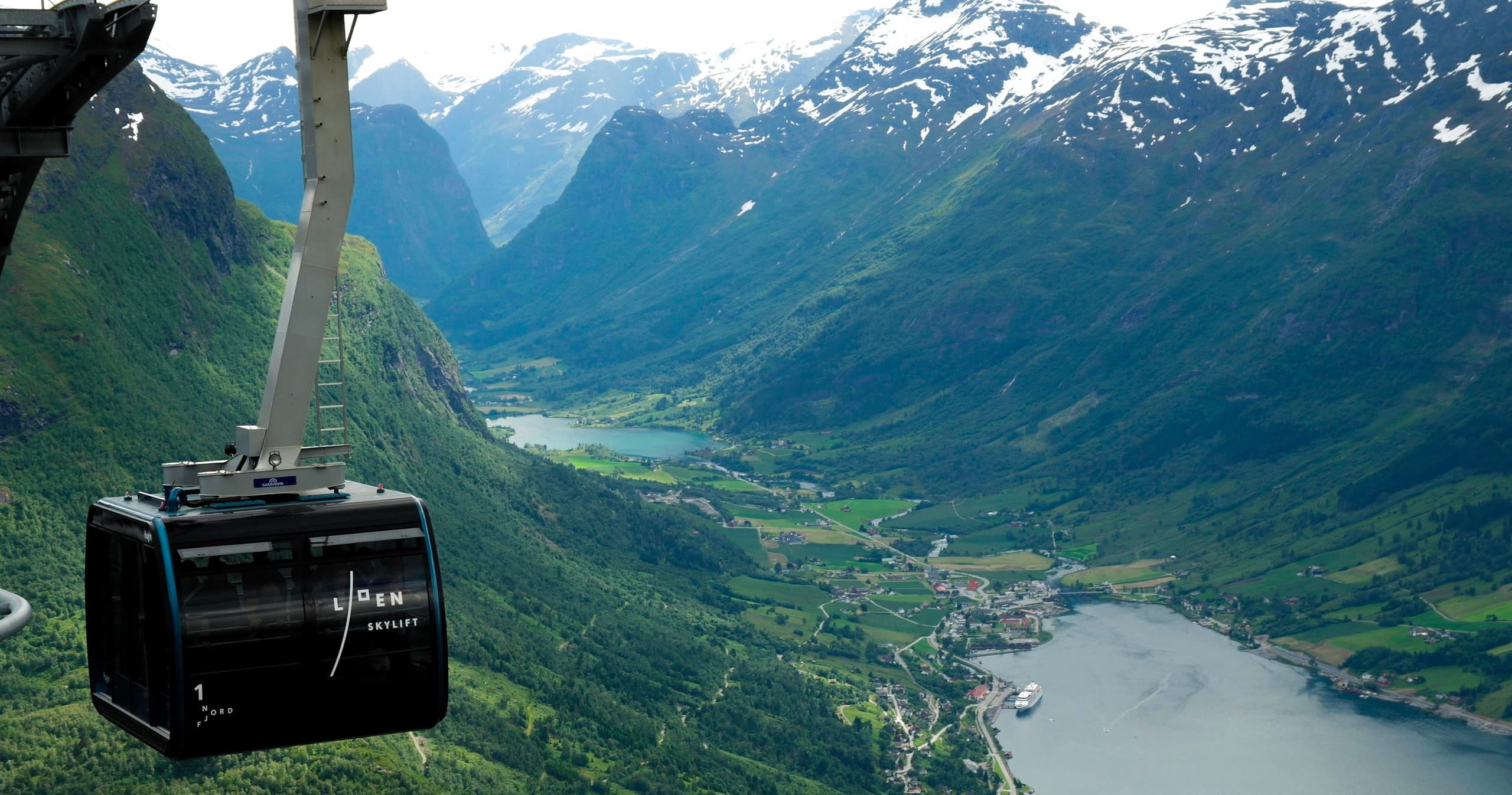 Cable car gliding above Norwegian fjord valley with cliffs