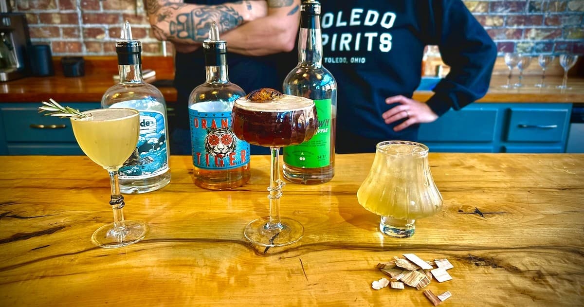 Cocktail glasses and spirits on wooden bar in indoor studio