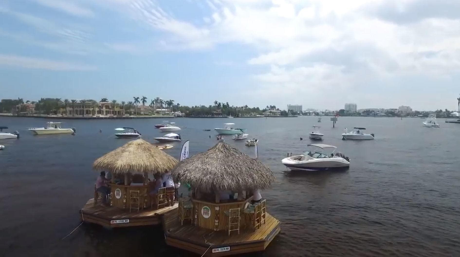 Aerial view of two tiki raft boats among harbor vessels