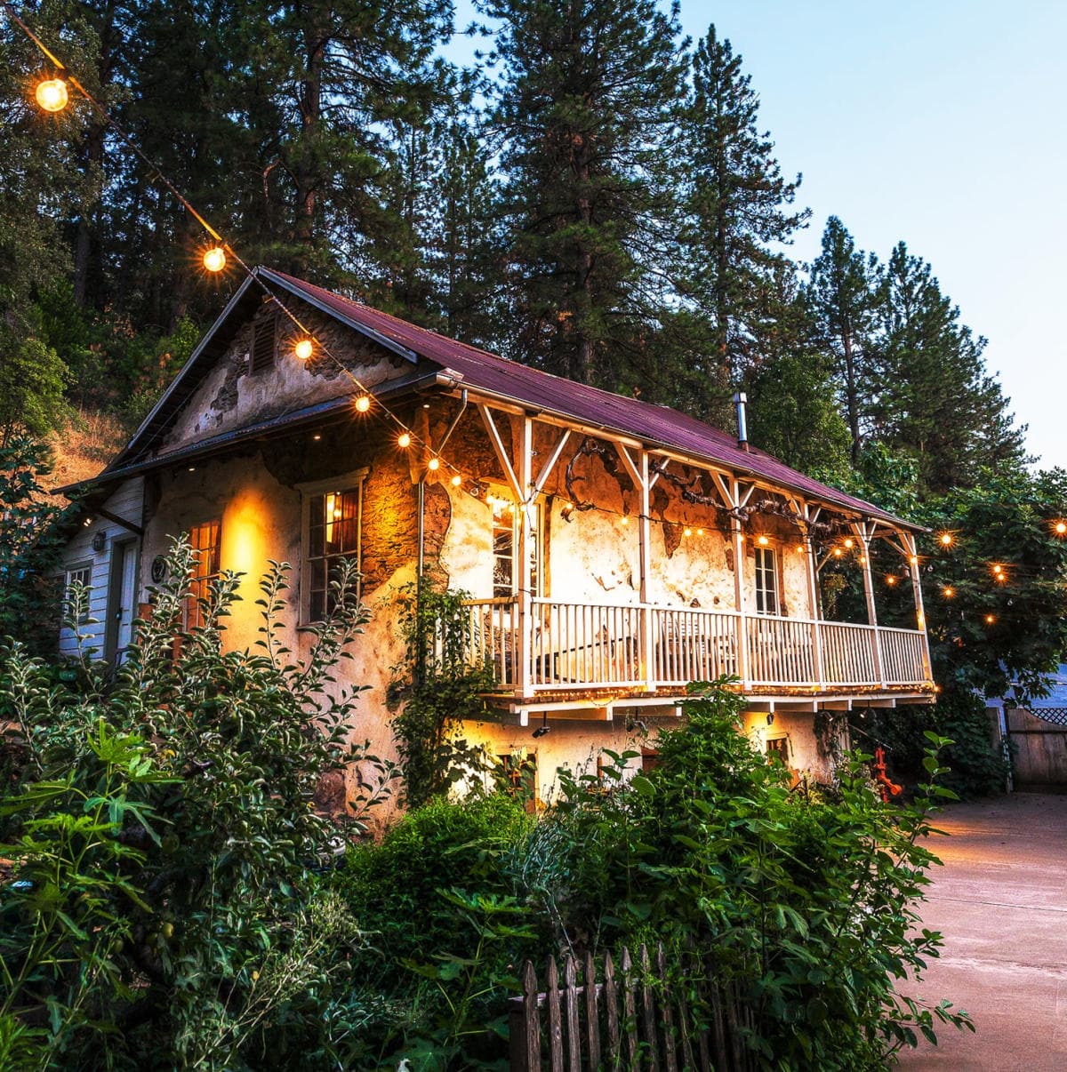 Forest cabin with string lights on porch, cozy outdoor stay