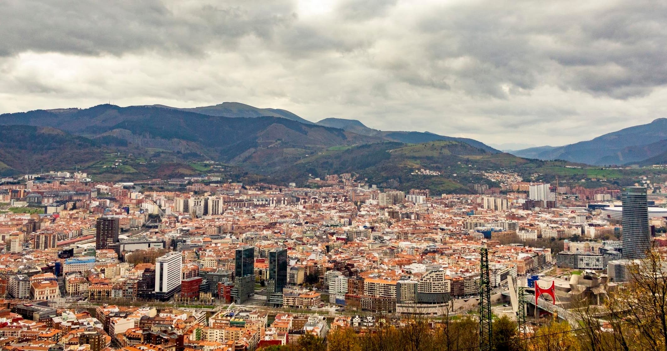 Wide aerial Bilbao panorama with mountains, urban hiking outlook