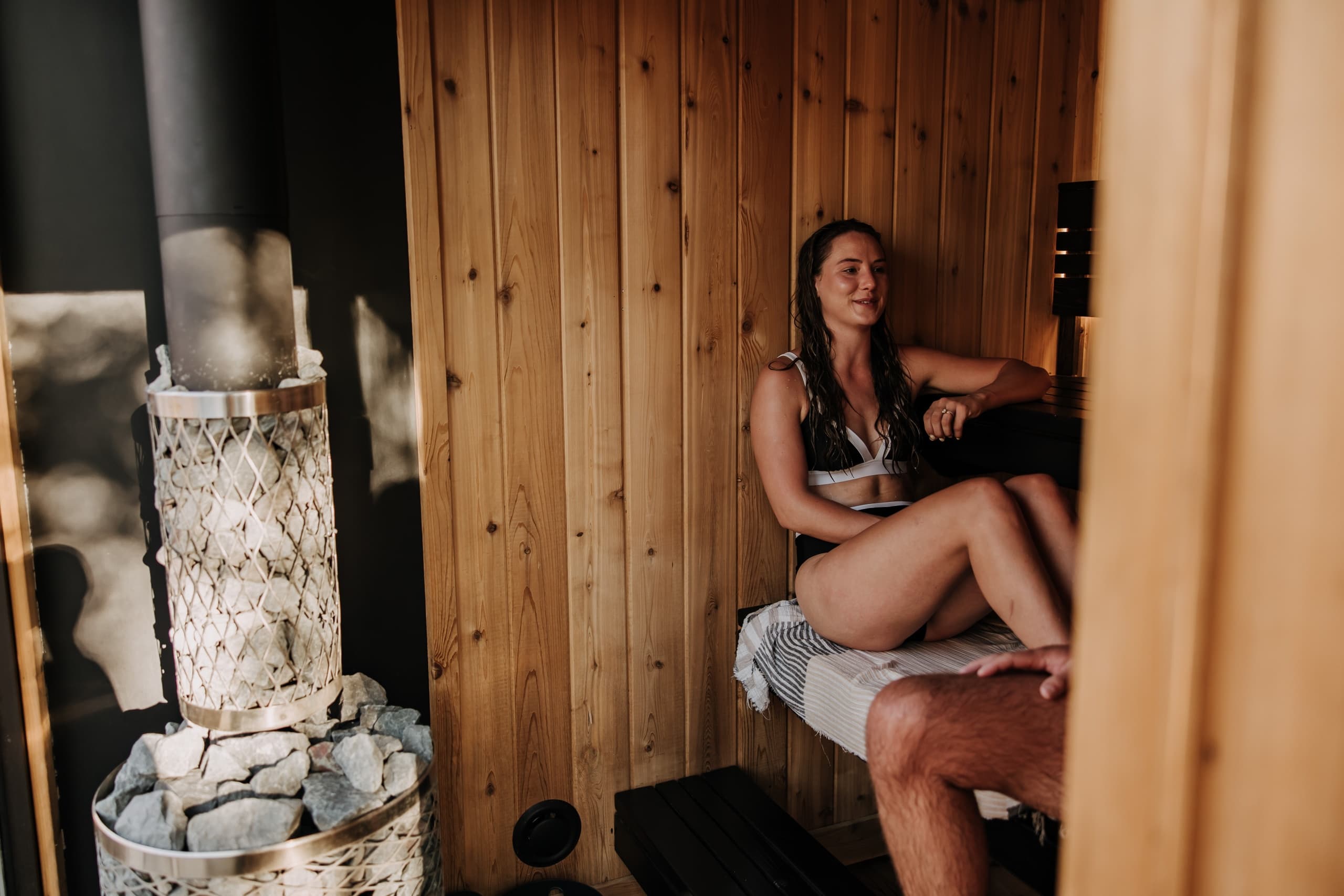 Relaxing solo sauna experience by wood stove inside cedar sauna