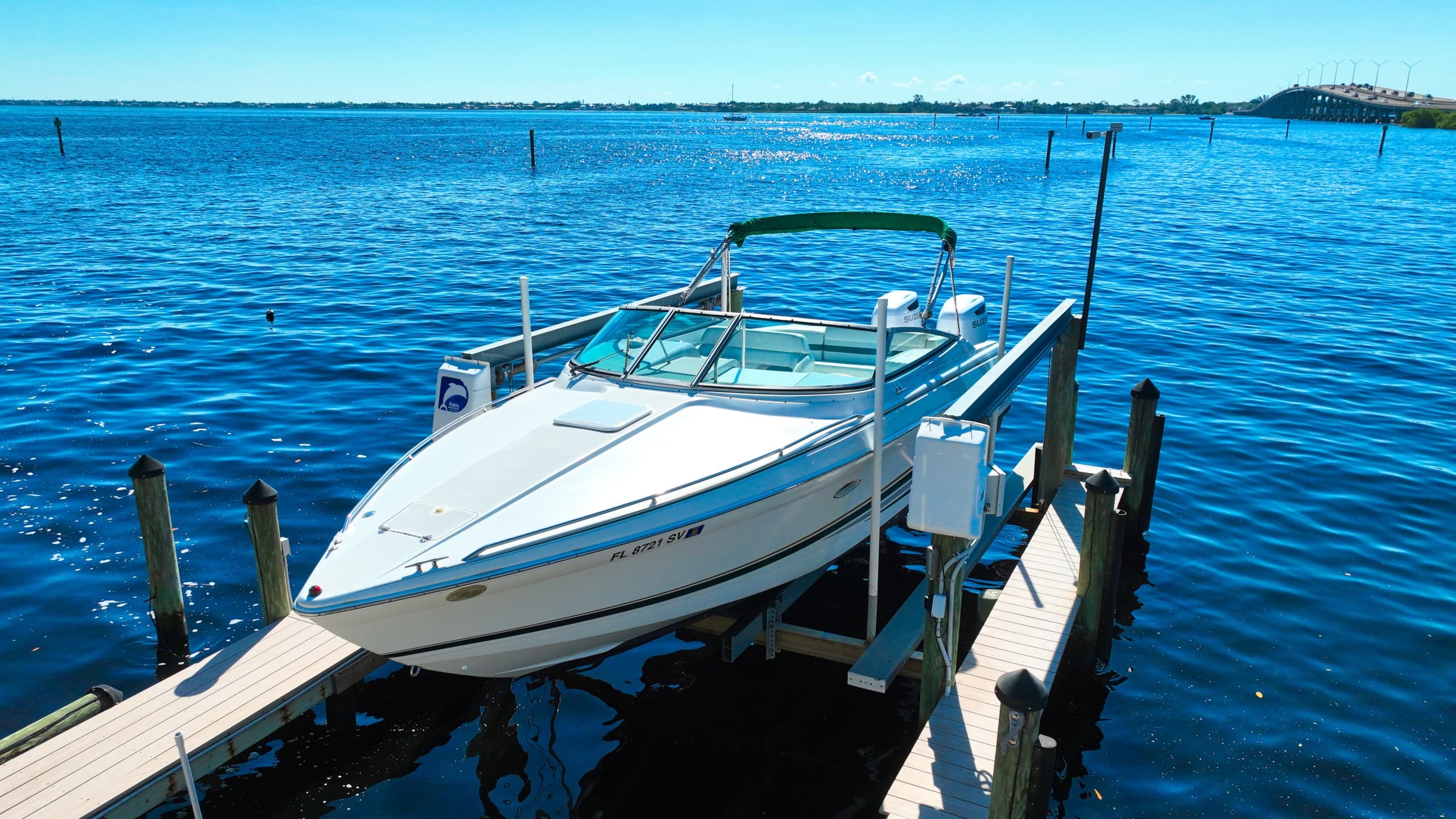 Small motorboat moored at dock on bright blue bay horizon