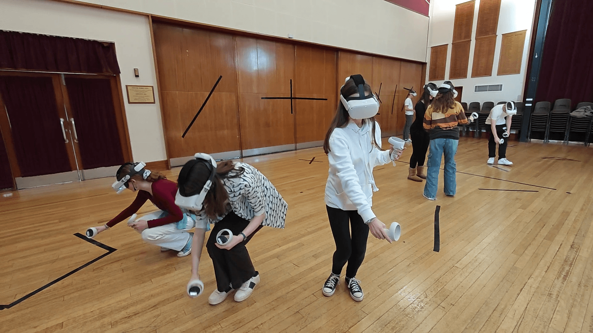 Students using VR headsets in indoor gym for virtual education
