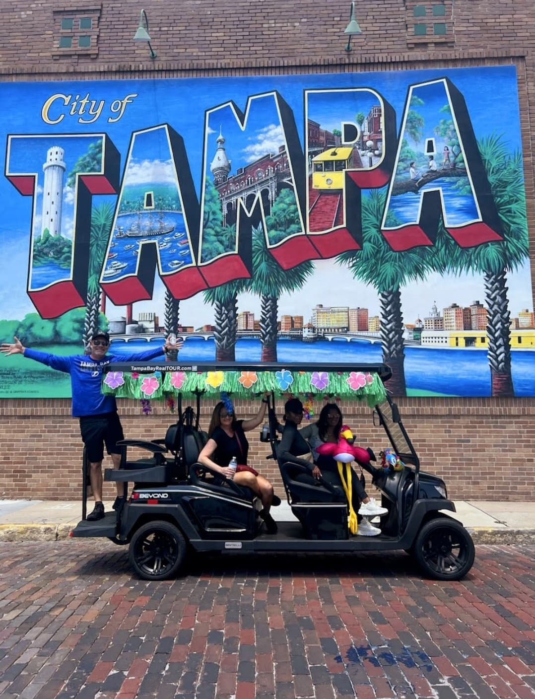 Open-air cart tour group in Tampa in front of mural