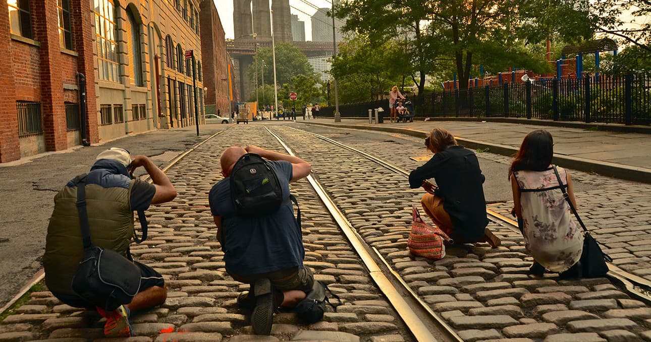 Photographers shooting cobblestone street and rail tracks, street tour