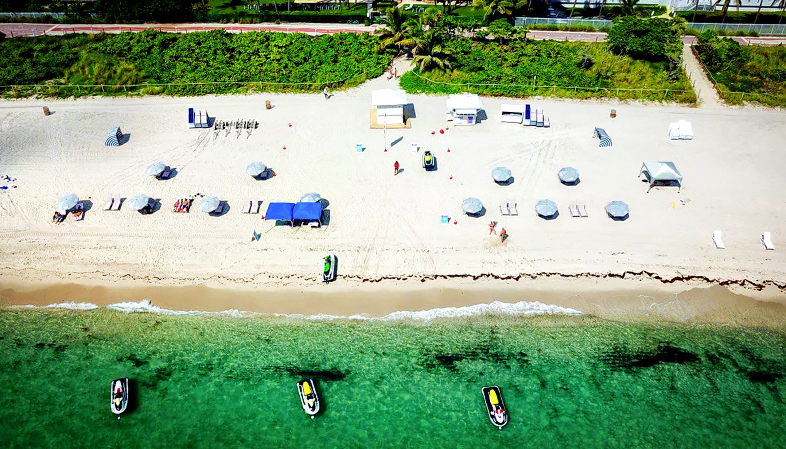 Aerial beach view with turquoise water and parked jet skis
