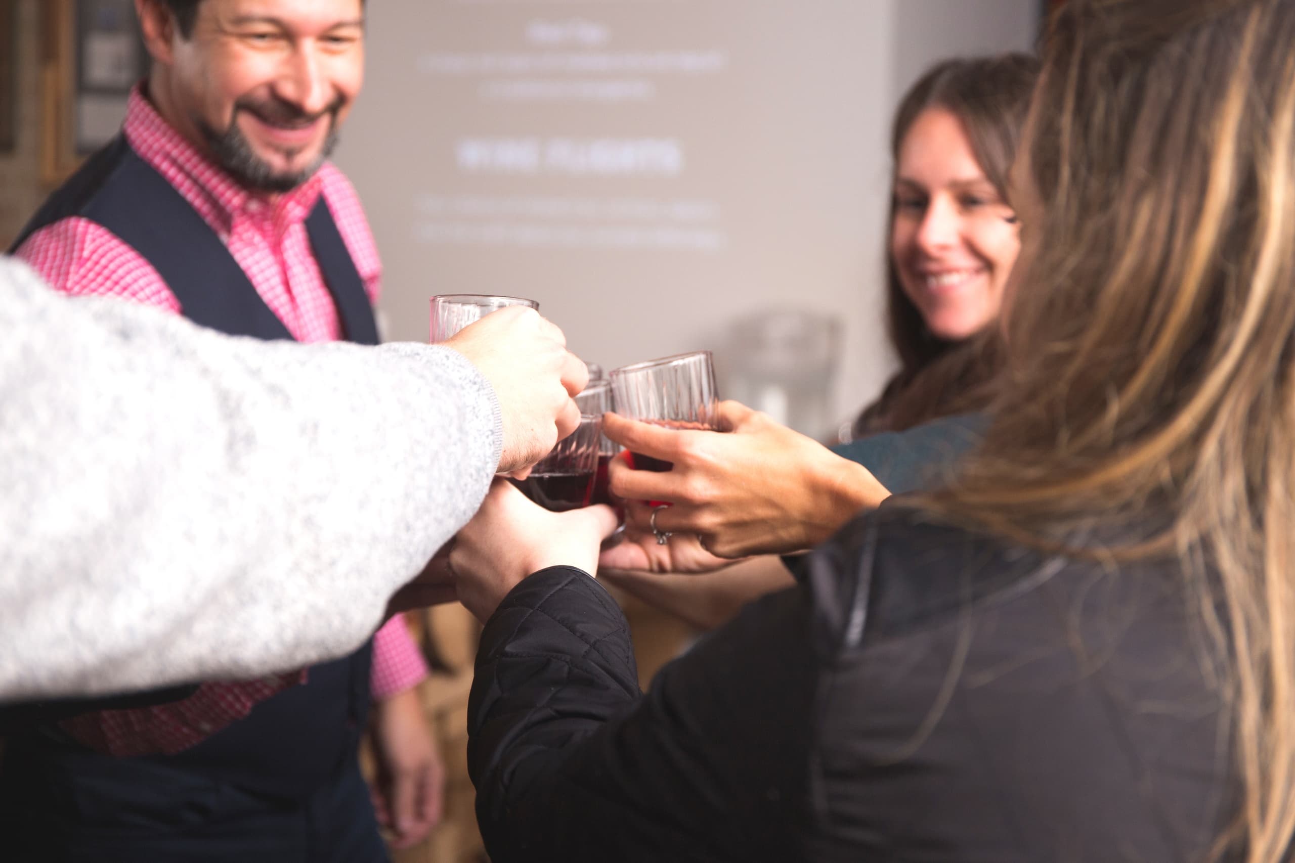 Small group toasting drinks at indoor tasting during food tour