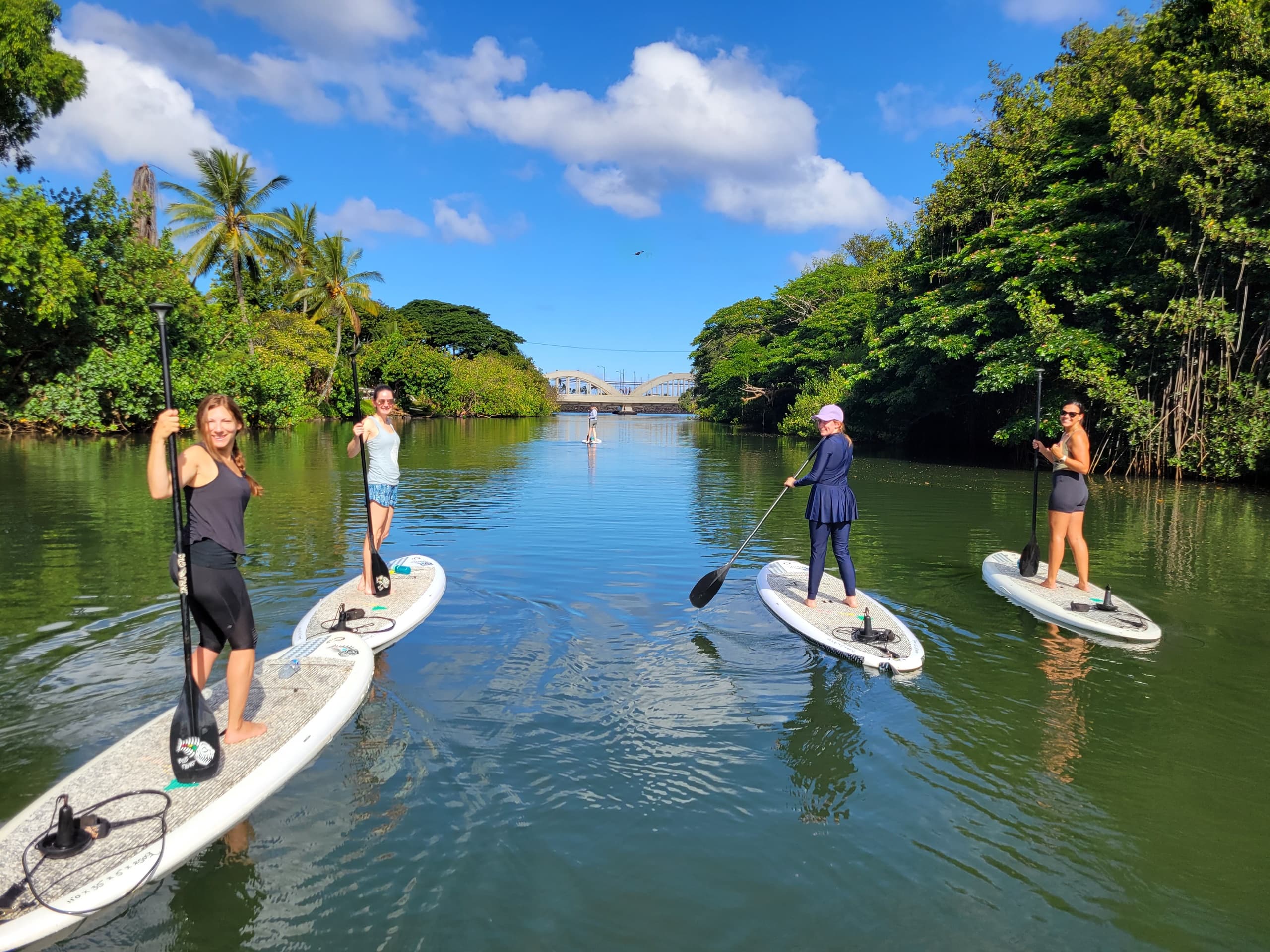Stand-up paddleboarding with group on calm tropical river view