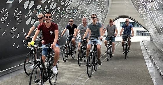 Cyclists riding through modern tunnel on urban adventure bike tour