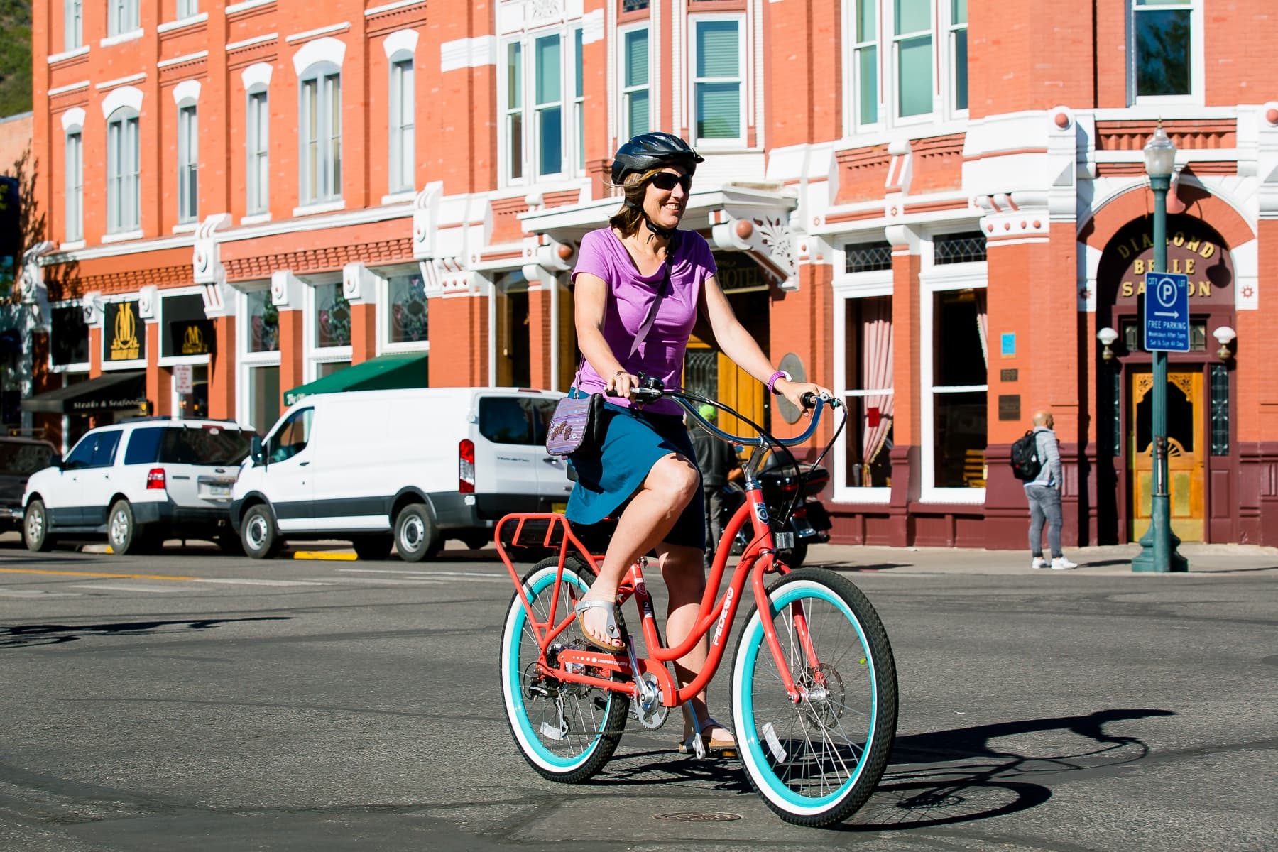 Woman cycling through vibrant city streets on cruiser bike