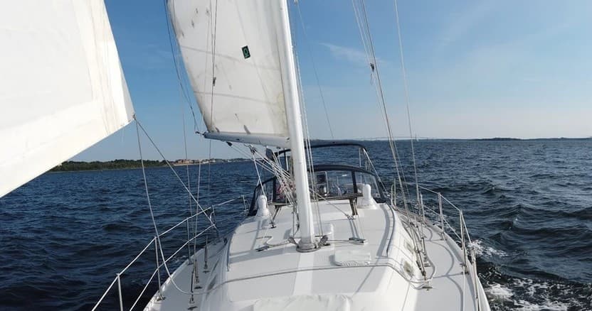 View from sailboat bow navigating open sea, hands-on sailing