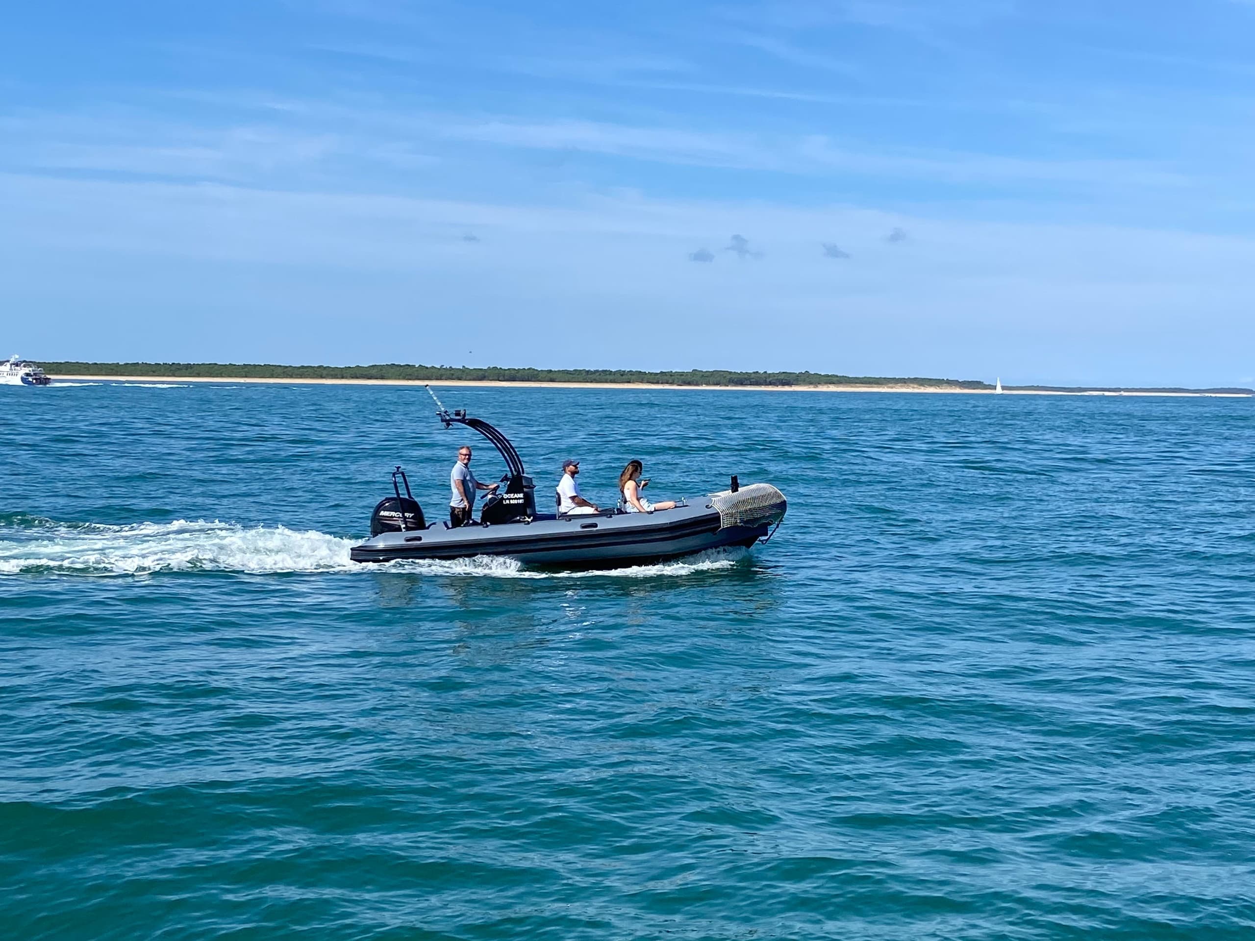 High-speed RIB boat cutting through turquoise ocean near coast