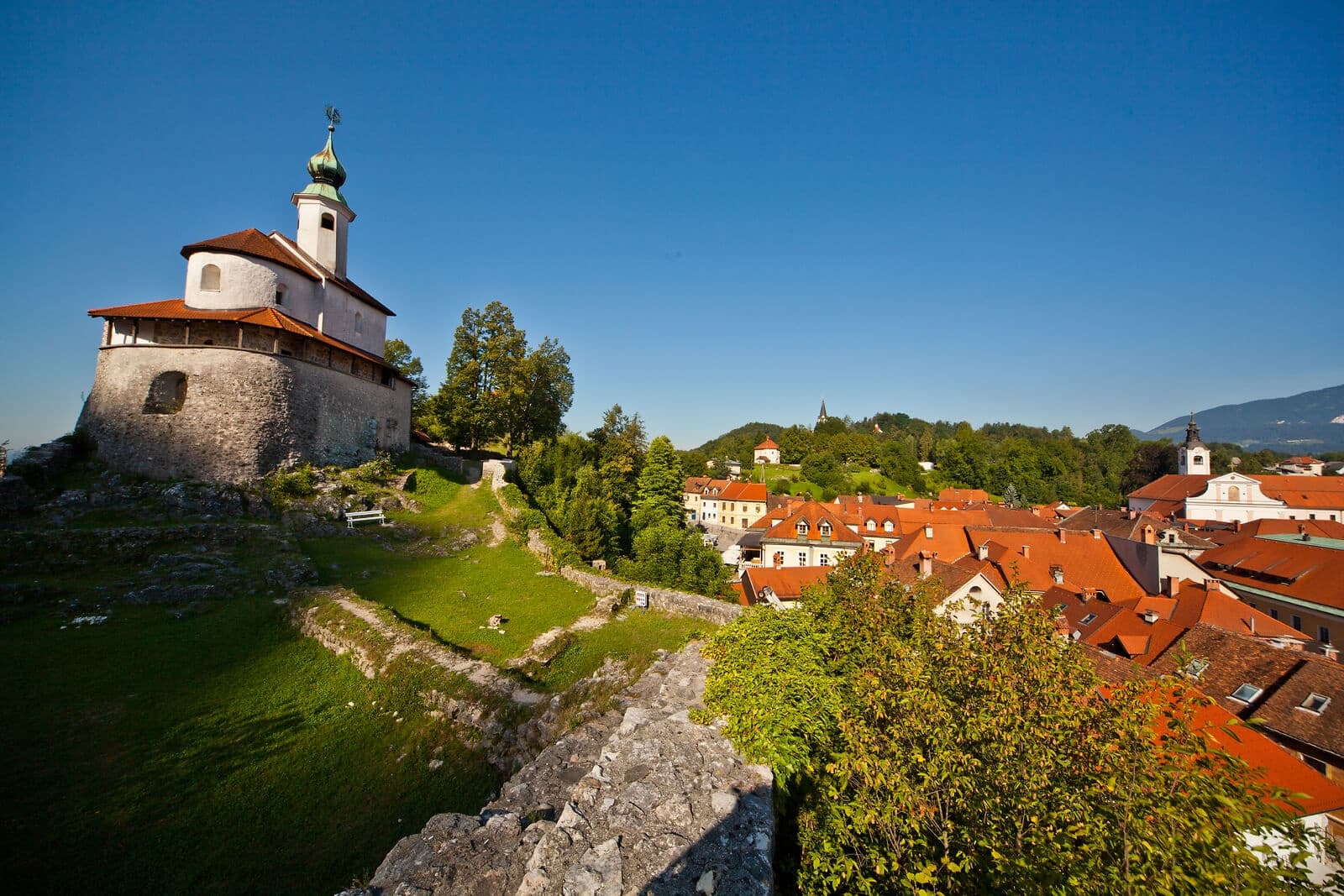 Historic hilltop church overlooking red-roof town and hills