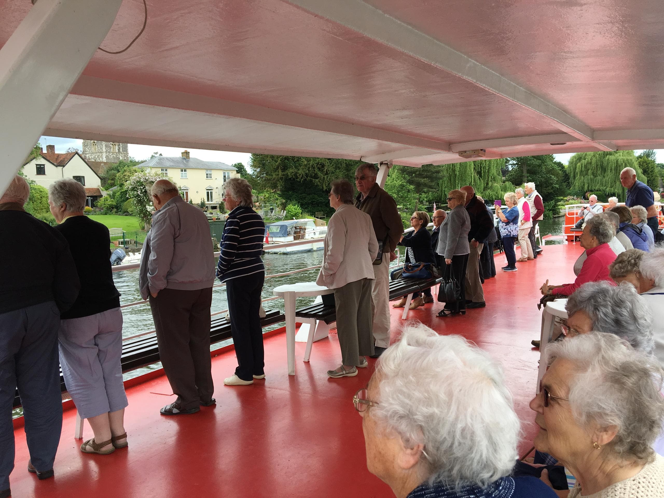 Guests enjoying open deck river cruise with waterside views