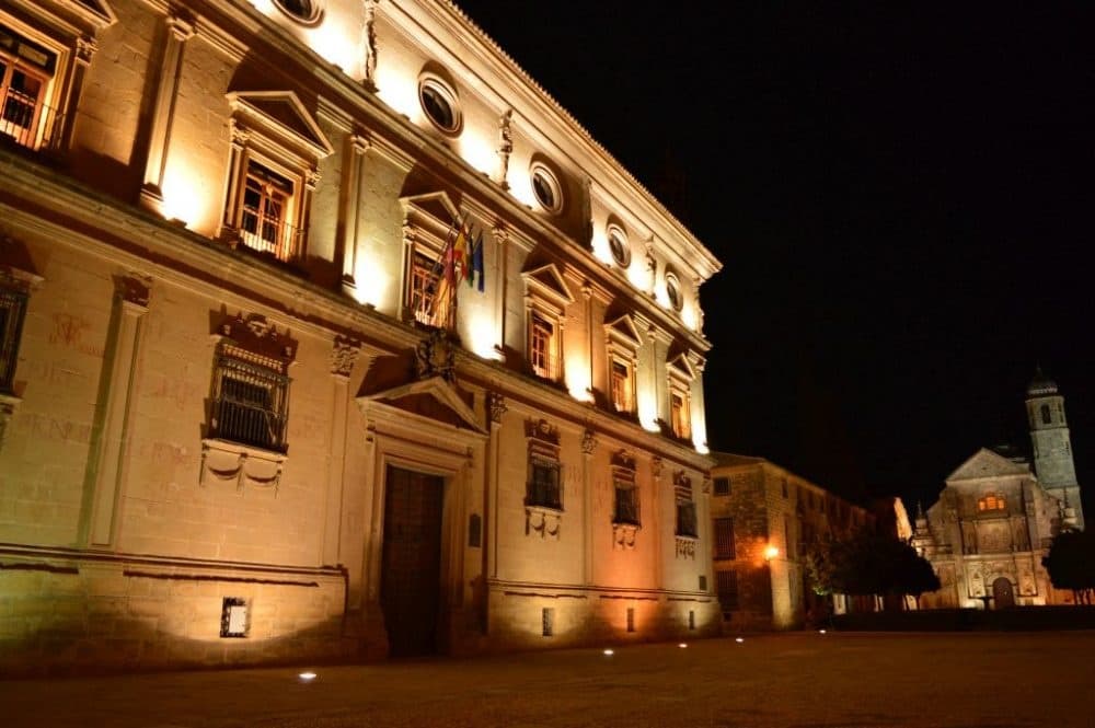 Night-lit historic building façade, evening cultural sightseeing walk