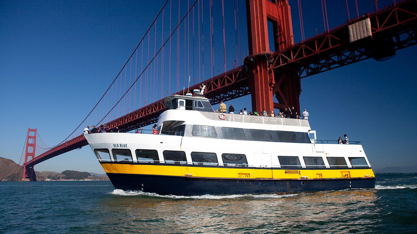 Sightseeing ferry cruising under Golden Gate Bridge in San Francisco