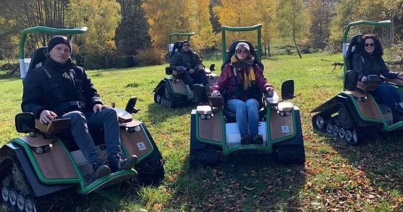 Group tracked buggies parked in autumn meadow during tour