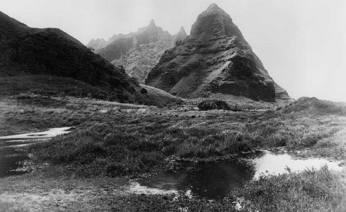 Black-and-white mountain valley panorama with reflective pools