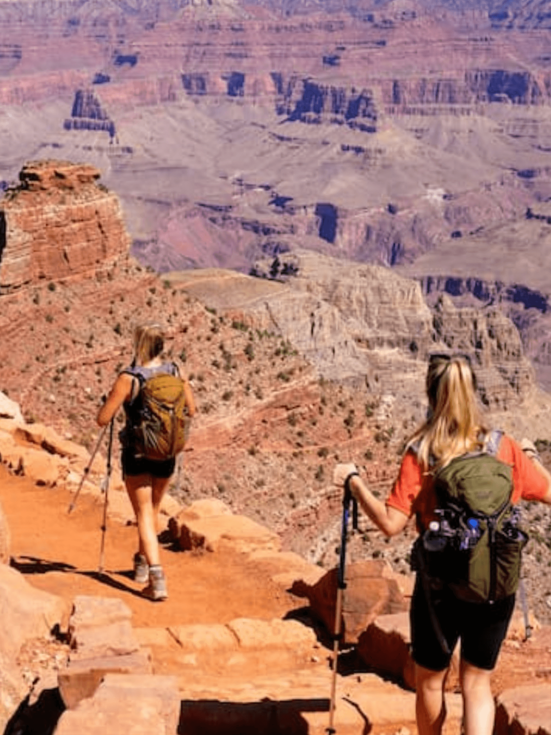 Two hikers trekking along Grand Canyon rim, scenic desert vista