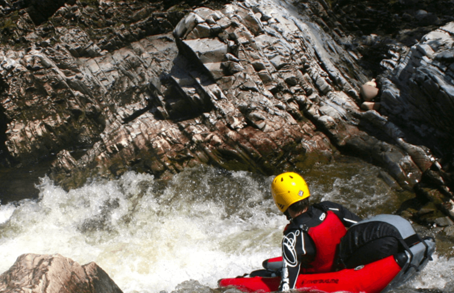 Solo kayaker navigating a rocky river drop in whitewater