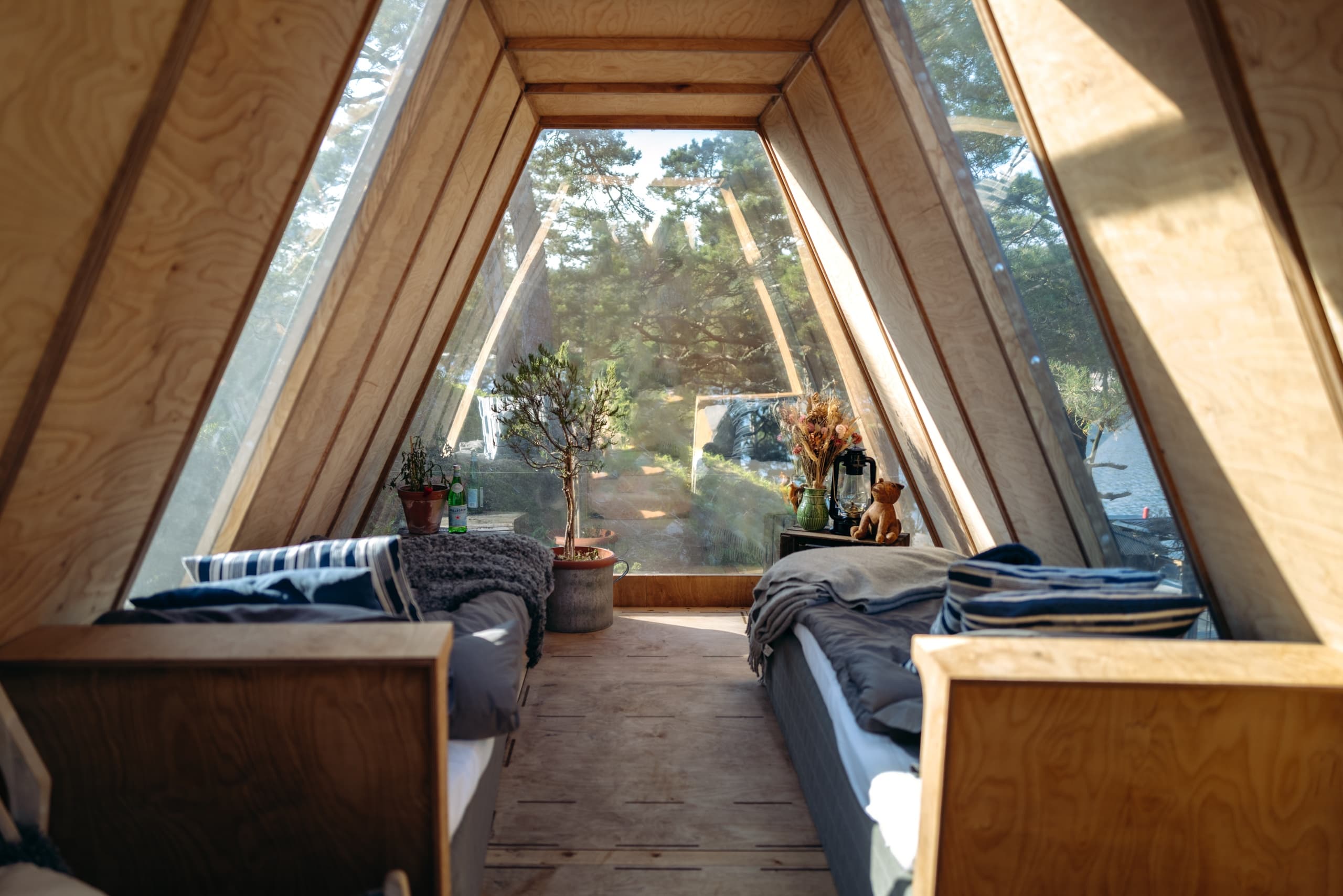 A-frame cabin interior with twin beds, forest glamping retreat