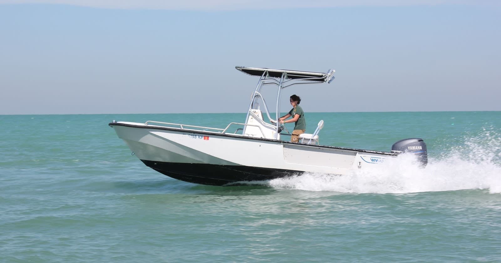 Small sport boat powering through calm turquoise Florida Keys seas
