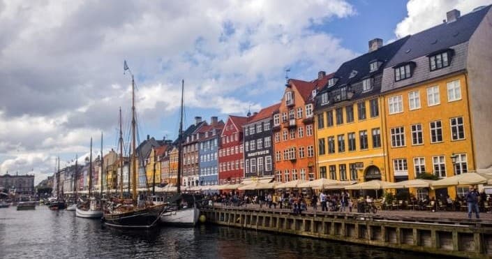 Colorful Nyhavn canal boats and waterfront cafes in Copenhagen