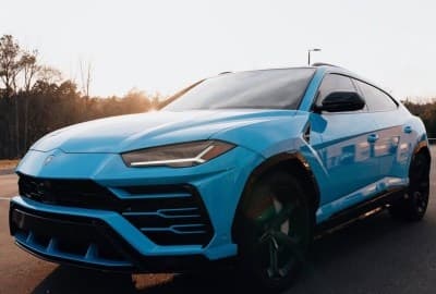 Blue Lamborghini Urus parked at sunset, ready for adventurous drive